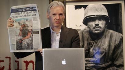 Julian Assange con un periódico
