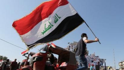 متظاهر يحمل العلم العراقي