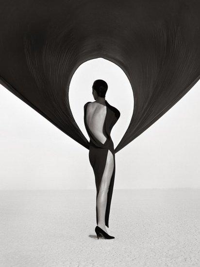 A black and white image titled 'Versace Dress (Back View), El Mirage 1990' by Herb Ritts