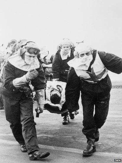A casualty from HMS Sheffield is carried on a stretcher