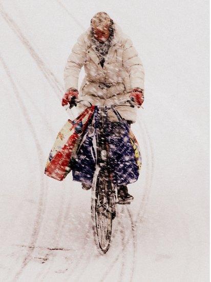 A person cycling through snow in the Netherlands
