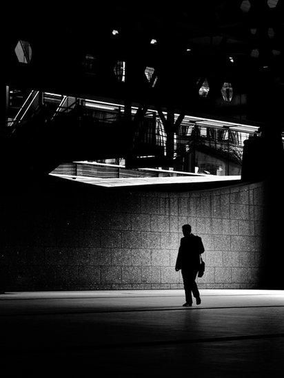 A man walking under offices at Broadgate, London