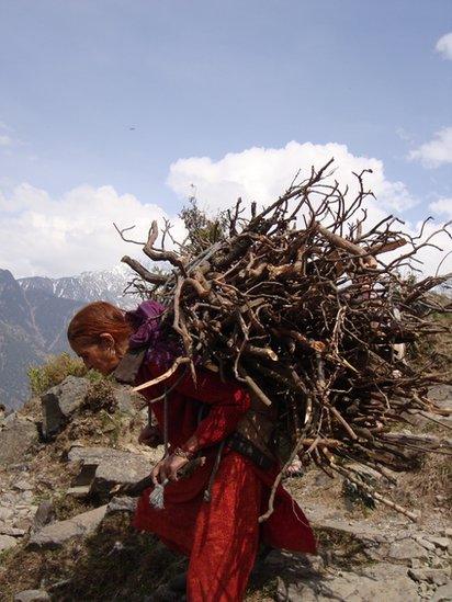 A woman carrying wood