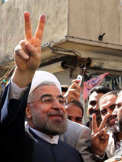 Iranian moderate presidential candidate, Hassan Rouhani flashes the sign of victory as he leaves a polling station after voting on June 14.