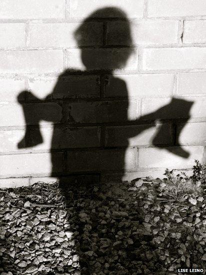 Shadow of child holding boots