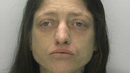 Custody photo of Kimberley Ann Hawkins. She is wearing no make-up and has brown hair. She has a vacant look on her face.