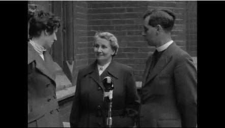 Ella Gordon being interviewed, with another, male, minister standing beside her.