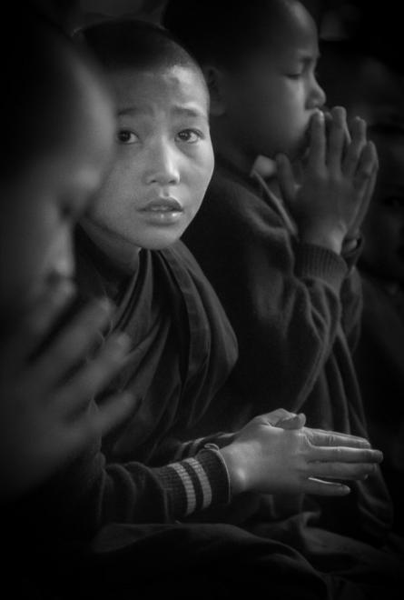 Un monje novicio entre sus compañeros durante las oraciones en el remoto monasterio cerca de Hsipaw, en el este de Birmania