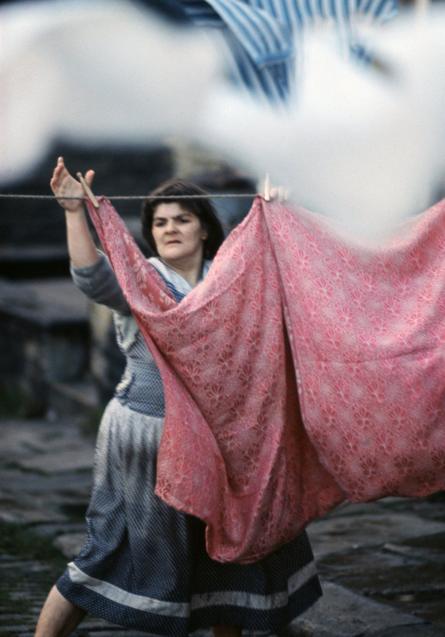 إمرأة تعلق ملابسها المغسولة على حبل للتجفيف