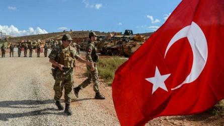 Militares y taques turcos con la bandera turca en primer plano.