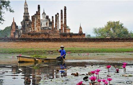 Gardener in front of ruins of Sukhothai, capital of the 13th-15th Thai-speaking kingdom of the same name