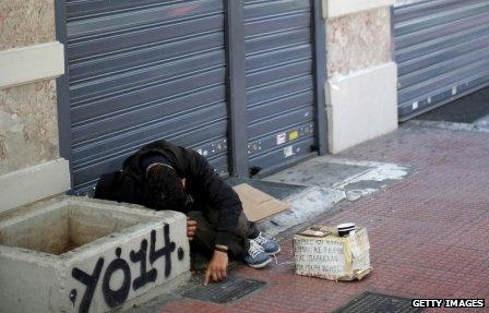 Homeless man in Greece outside a closed bank