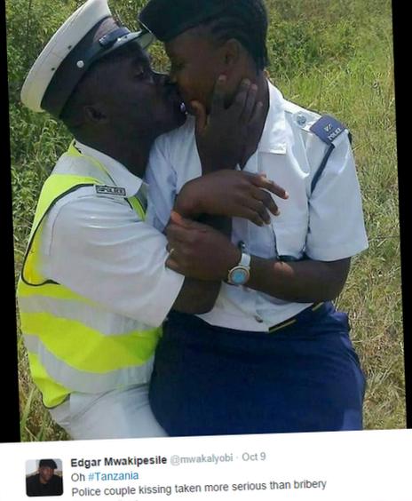 Two Tanzanian police officers kissing