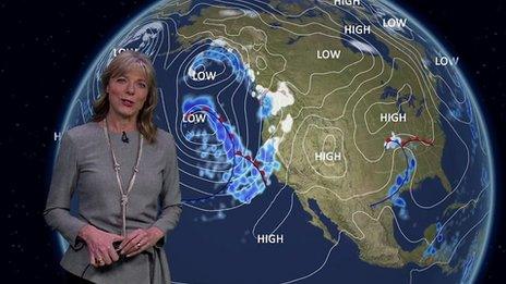 Louise Lear stands in front of a weather map of the US