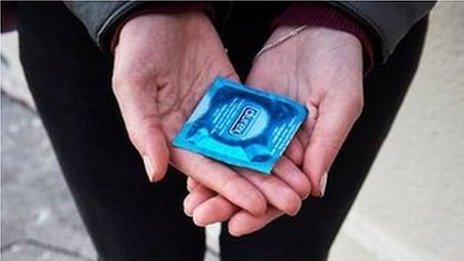 woman holding condom
