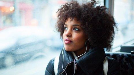 woman listening to headphones on train