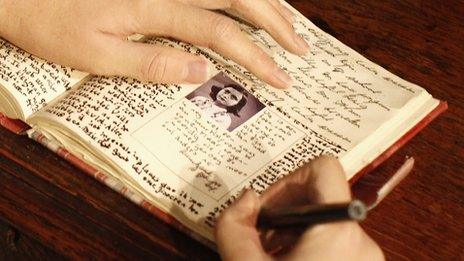 model of Anne Frank writing her diary