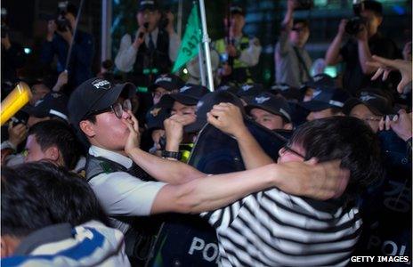 Participants of a candle-lit rally clash with police following vigil for victims of the Sewol ferry during which they also denounced the government response to the disaster