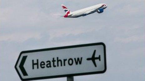 A plane is seen above the Heathrow sign