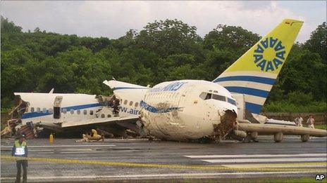 A police officer stands by a crashed plane sitting on the runaway at the airport on San Andres island in Colombia