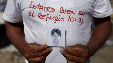 Alberto Segovia, outside the San Jose mine in Copiapo, Chile, shows a portrait of his brother Dario Segovia, 48, one of 33 miners trapped inside
