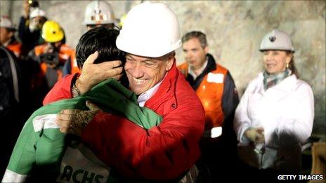 In this handout from the Chilean government, Ariel Ticona, the 32nd miner to be rescued, is hugged by Chile's president Sebastian Pinera on October 13, 2010 at the San Jose mine near Copiapo, Chile.