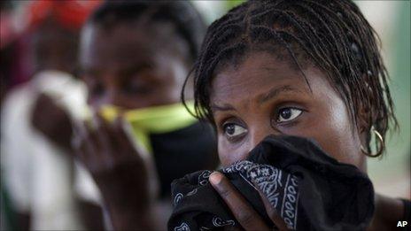 Women cover their mouths as their children are treated in hospital in Grande-Saline, Haiti, 23 October 2010