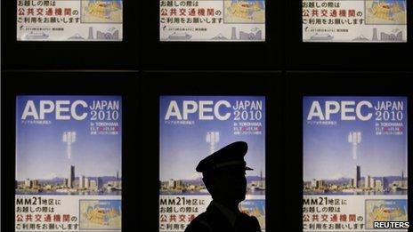 Policeman stands in front of Apec signboard in Tokyo on 10 November 2010