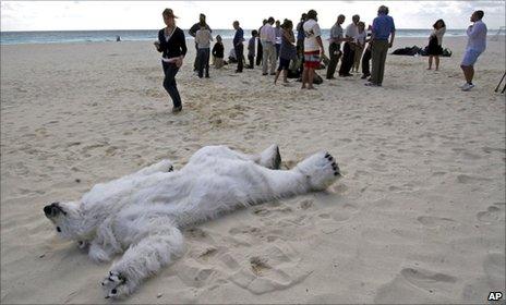 Man dressed in polar bear suit playing dead on Cancun beach (AP)