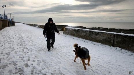 Man and dog take walk through snow on Porthcawl seafront