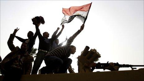 Men stand on top of an armoured Egyptian Army vehicle during a protest in Cairo, 29 January 2011