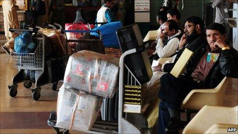 Passengers wait outside the departure lounge of the airport during a strike by employees of the flagship Pakistan International Airlines (PIA) in Karachi on February 8, 2011.