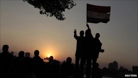 The sun sets on protesters as they demonstrate in Tahrir Square in Cairo February 11, 2011. A
