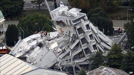 Rescue workers climb onto the collapsed Pyne Gould Guinness Building in central Christchurch, New Zealand, Tuesday, Feb. 22 2011.