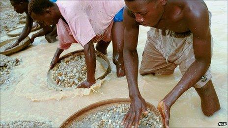 Workers pan for diamonds in a government-controlled diamond mine in Sierra Leone on 15 June 2001 near Kenema