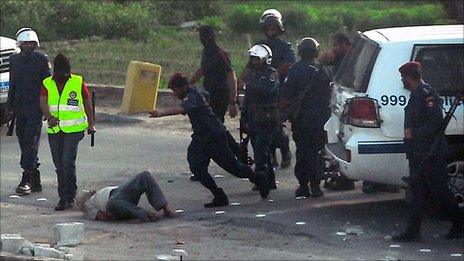 A policeman kicks a bound man in Manama, 30 March (obtained from a human rights group)