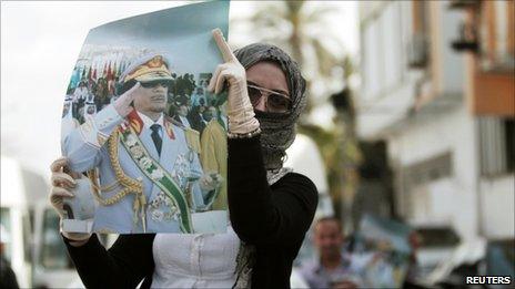 A supporter displays a picture of Libyan leader Muammar Gaddafi during an anti-coalition protest in Tripoli, 2 April 2011