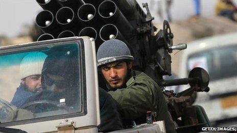 Libyan rebels ride in a vehicle with a rocket launcher on the road to Brega, 6 April