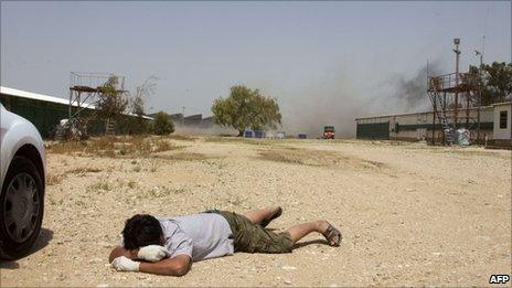 A foreign worker lies on the ground as mortar shells hit the southern Israeli kibbutz of Nir Oz, 8 April