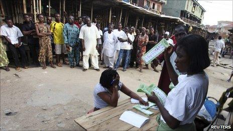 An electoral officer counts ballots as people watch at the end of the parliamentary elections in Oshodi district in Nigeria"s commercial capital of Lagos April 9, 2011