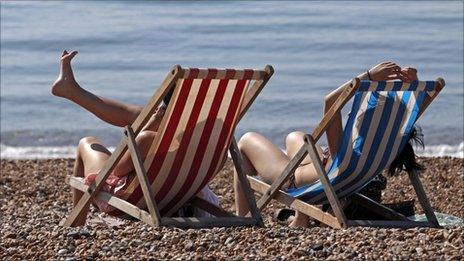 People enjoy the sunshine on the beach in Brighton, southern England