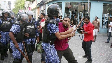 Maldivian police detain a journalist at a protest in Male, Maldives, on 1 May 2011