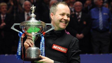 John Higgins holds the World Championship trophy aloft after beating Judd Trump in the final
