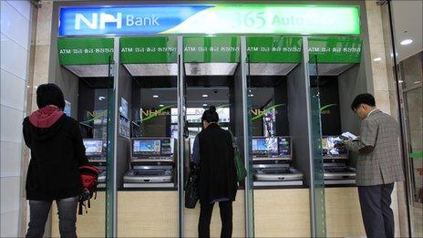 Customers use cash machines at a Nonghyup bank on 3 May 2011