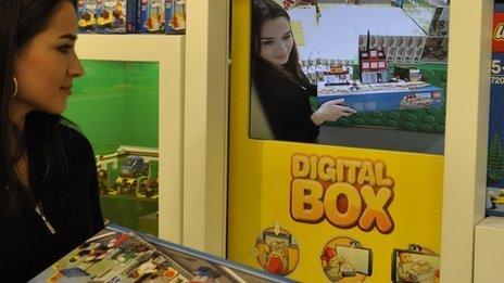 A shopper examines an augmented reality 3D Lego model before deciding whether to buy