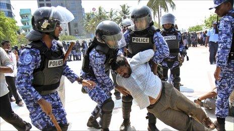 Maldives police arrest one of the protesters during an opposition-led demonstration against soaring prices in Male, Maldives, Friday, May 6, 2011.