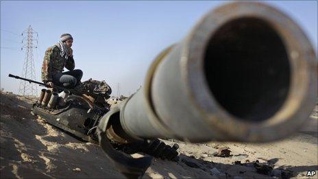 Rebel fighter sits on destroyed tank