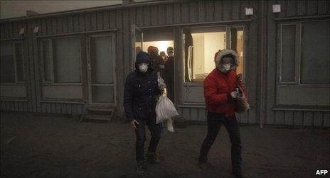 Туристы в масках покидают отель возле извергающегося вулкана