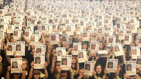 10,000 members of the Rock Choir hold up posters showing pictures of missing children, at Wembley Arena