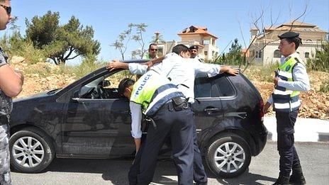 Palestinian police officers make a fake arrest as part of a training exercise in Ramallah